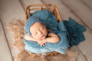 bebelus in albastru care doarme linistit la sedinta foto de nou nascut